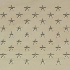 以下が含まれることがあります： 薄い茶色の木製の表面に、50個の灰色の星が並んだパターンが描かれているクローズアップ。