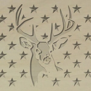 Puede incluir: Un recorte de madera de una cabeza de ciervo con cuernos, sobre un fondo de un campo de estrellas. La cabeza de ciervo está en el centro de la imagen, y las estrellas están dispuestas en filas.