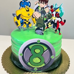 May include: A green frosted cake decorated with cartoon characters. The cake has a large number 8 and several character cutouts. A banner that says "BIRTHDAY" is visible in the background. The cake sits on a gold scalloped cake board.