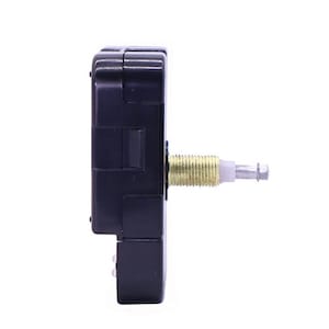 May include: A black clock movement with a gold-colored winding stem. The movement is designed for use in a clock.