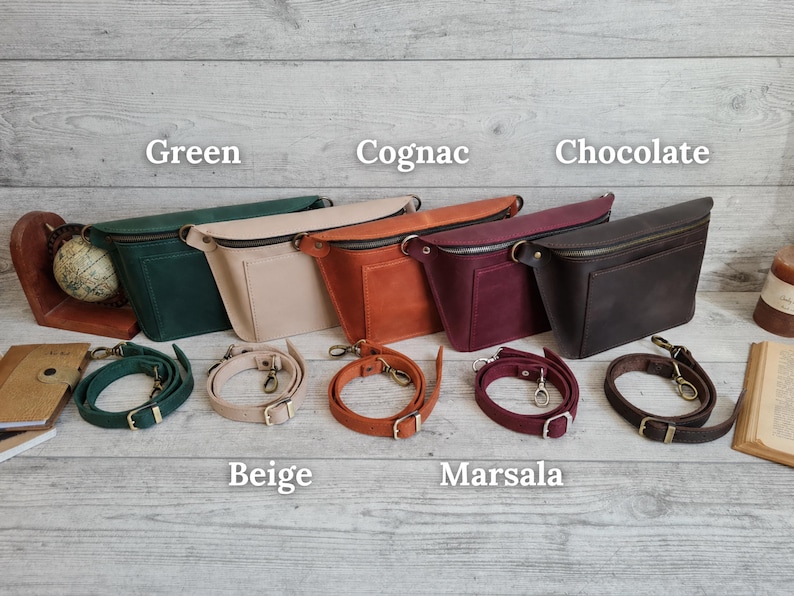 Puede incluir: Cinco ri&ntilde;oneras en colores verde, beige, co&ntilde;ac, marsala y chocolate, cada una con cremallera superior, un bolsillo frontal y una correa ajustable desmontable con herrajes met&aacute;licos. Las bolsas est&aacute;n etiquetadas como Green, Cognac, Chocolate, Beige, Marsala.