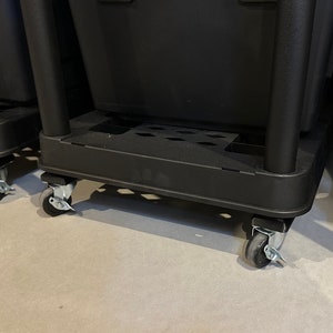 May include: A black plastic storage bin base featuring a rectangular frame with four vertical support pillars and four swivel caster wheels with metal hardware. The base includes a perforated platform surface for stability and mobility.