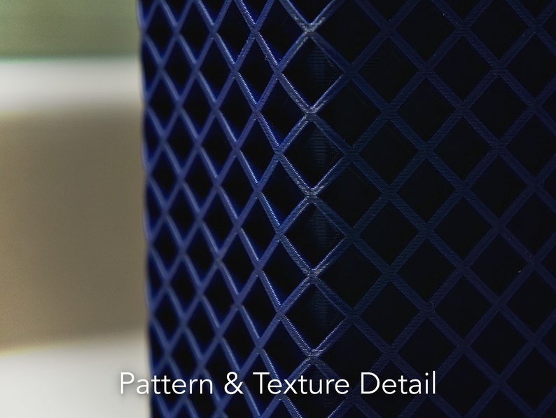 May include: A close-up of a dark blue object with a diamond-shaped pattern. The pattern is raised and creates a textured surface.