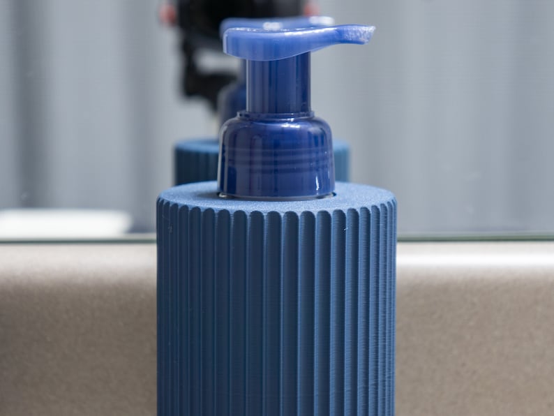 May include: A blue soap dispenser with a ribbed base and a blue pump top.