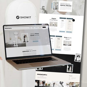May include: A laptop displays a website for Detroit Photo Booth Rentals, showcasing services and pricing. Accompanying the laptop are printouts detailing digital and print photo booth options. The Showit logo is visible.