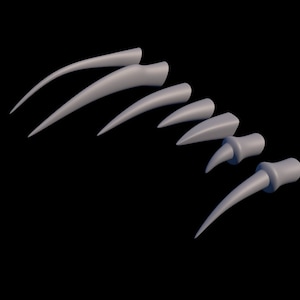 Può includere: Un set di sette artigli di plastica grigi di diverse dimensioni. Gli artigli sono affilati e appuntiti e sono disposti a semicerchio.