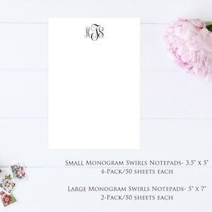 May include: A white notepad with a black monogram "KTS" at the top. The notepad is on a white wooden surface. The text below the notepad reads "SMALL MONOGRAM SWIRLS NOTEPADS - 3.5" x 5" 4-PACK/50 SHEETS EACH LARGE MONOGRAM SWIRLS NOTEPADS - 5" x 7" 2-PACK/50 SHEETS EACH"