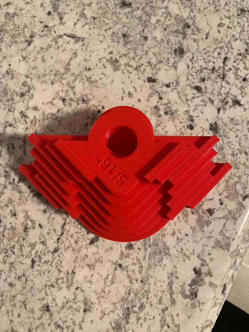 May include: A set of six red plastic corner miter jigs, stacked on top of each other. The jigs are labeled "91/8".