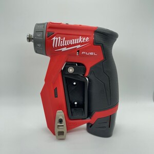 Puede incluir: Un taladro atornillador inal&aacute;mbrico Milwaukee FUEL 12V rojo y negro con un clip de cintur&oacute;n y un dial de velocidad variable. El taladro tiene un agarre de goma negro y un portabrocas de metal plateado.