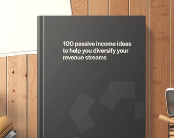 Op de afbeelding: Een zwart boek met de titel "100 ideeën voor passief inkomen om u te helpen uw inkomstenstromen te diversifiëren" in witte tekst. Het boek ligt op een houten oppervlak met andere objecten op de achtergrond.