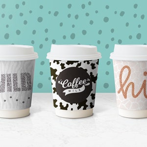 May include: Three disposable coffee cups with different animal print designs. The first cup has a zebra print with the word "WILD" in black text. The second cup has a cow print with the words "Coffee Milk" in black text. The third cup has a giraffe print with the word "hi!" in orange text.