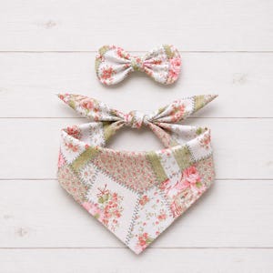 May include: A fabric pet bandana and a matching bow tie featuring a patchwork design of various floral patterns in shades of pink, white, and sage green. The bandana has pointed ends that tie together, and the bow tie has a central knot.