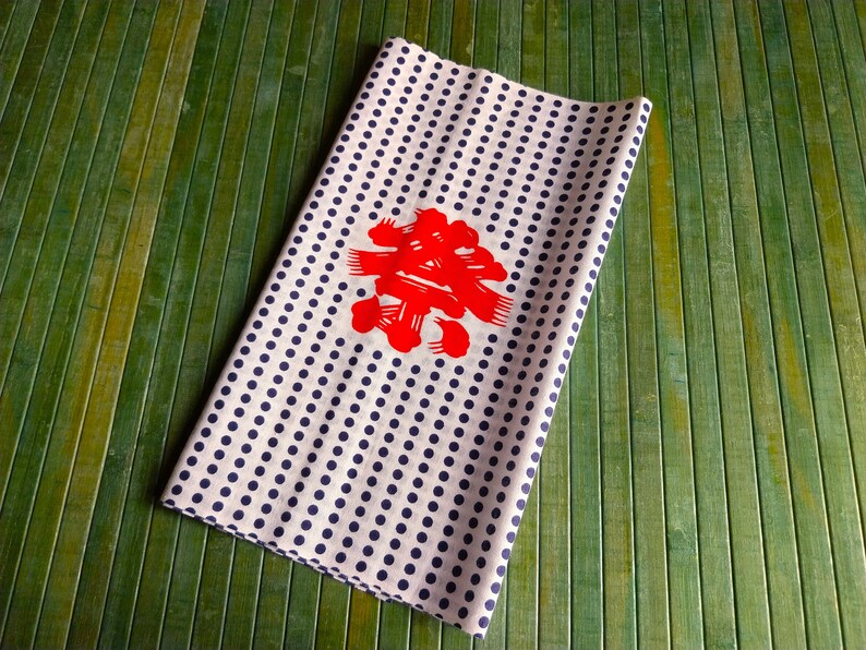 May include: White fabric with a navy blue polka dot pattern and a red Japanese character in the centre.