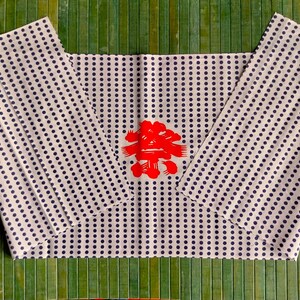 May include: White wrapping paper with a blue polka dot pattern. The paper is folded in half and has a red Chinese character in the centre.
