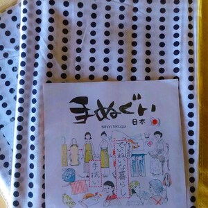 May include: A white fabric with black polka dots and a Japanese tenugui with illustrations of different ways to wear the tenugui. The tenugui has the text "手拭い" which means "hand towel" in Japanese. The text "てぬぐい" is also written in Japanese. The text "Nihon Tenugui" is written in English. The text "日本" is written in Japanese and means "Japan".