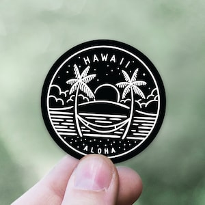 May include: Black and white sticker with a palm tree silhouette, a hammock, and the words "HAWAII ALOHA" in a circle.