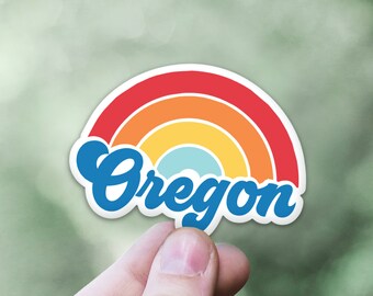 May include: A sticker with a rainbow design and the word "Oregon" in blue cursive lettering.