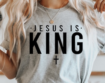 May include: Gray t-shirt with the text "JESUS IS KING" in black lettering and a small black cross below the text.
