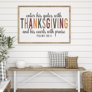 K&ouml;nnte beinhalten: Ein gerahmter Druck mit dem Text "enter his gates with THANKSGIVING and his courts with praise PSALMS 100:4" in einer rustikalen Bauernhaus-Umgebung. Der Druck wird an einer wei&szlig;en Schiffslappenwand &uuml;ber einer Holzbank mit Kissen gezeigt.