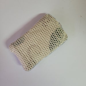 May include: A beige mesh produce bag with a green camouflage pattern. The bag is made of a soft, breathable material and is perfect for storing fruits, vegetables, and other produce.