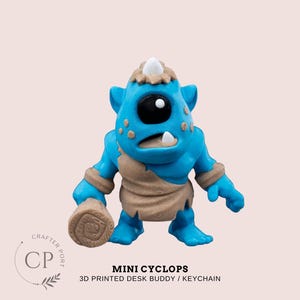 May include: A blue and brown 3D printed mini Cyclops desk buddy or keychain. The Cyclops has one large eye and a small horn on its head.