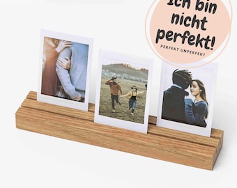 Könnte beinhalten: Ein Holz-Fotoständer mit drei gerahmten Fotos. Die Fotos zeigen Paare in verschiedenen Außenbereichen. Ein rosa Kreis mit dem Text "Ich bin nicht perfekt! Perfekt Unperfekt" befindet sich im Hintergrund.