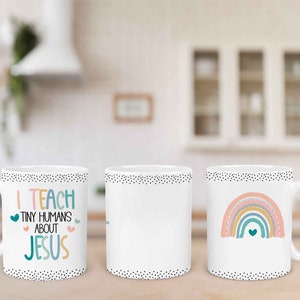 May include: Three white ceramic mugs with black polka dot trim. The mug on the left has the text "I teach tiny humans about Jesus" in colorful letters. The mug in the middle is blank. The mug on the right has a rainbow with a heart in the center.