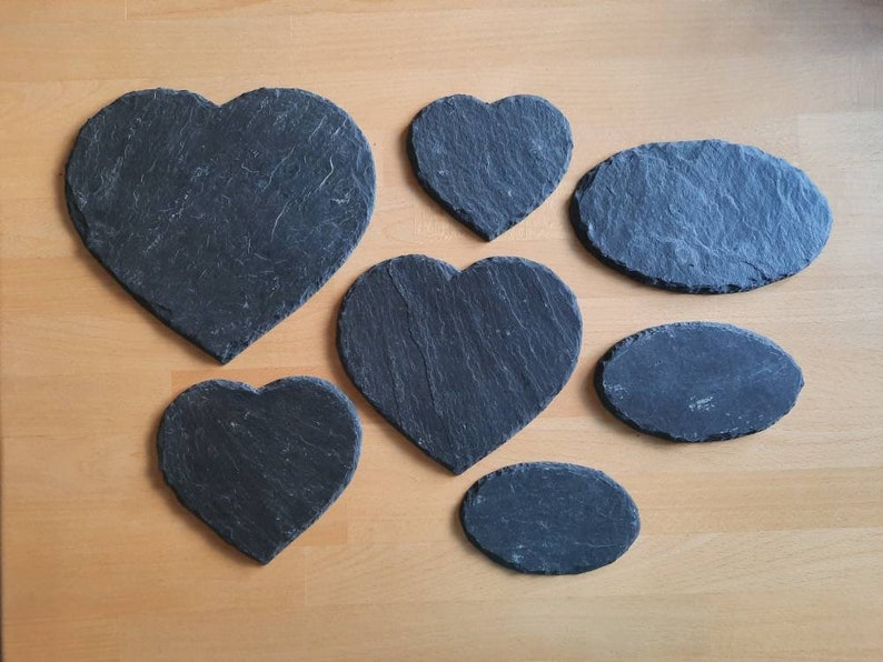 May include: A set of six black slate coasters in various heart and oval shapes.