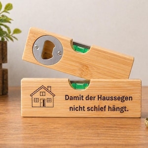 Pode incluir: Dois abridores de garrafas de bambu com design de nível. Um tem um abridor de garrafas e o outro um gráfico de casa e texto. Os abridores têm um abridor de garrafas prateado e uma bolha de nível verde.