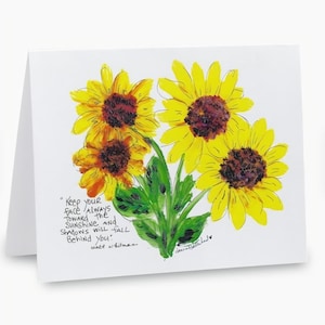 May include: Greeting card featuring a watercolor painting of four yellow sunflowers with brown centers and green leaves. The card includes a quote by Walt Whitman: "Keep your face always toward the sunshine, and shadows will fall behind you."