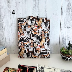 May include: A rectangular fabric pouch featuring a repeating pattern of various dog breeds in shades of brown, black, white, and tan. The pouch has a top flap with a snap closure and a small pocket on the front. The number 4 is visible in the corner.