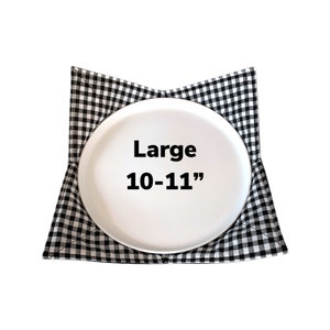 May include: Black and white checkered fabric plate holder with a white plate inside. The plate holder is labeled "Large 10-11" inches.