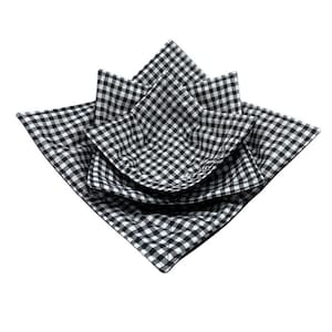 May include: Three black and white gingham fabric bowls, nested together. The bowls are made of quilted fabric and are designed to hold items like fruit or snacks.