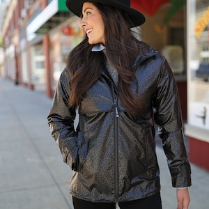 May include: A brown and black leopard print raincoat with a black hat. The raincoat has a zipper closure and a hood.