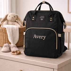 Black diaper bag with name Avery embroidered on front