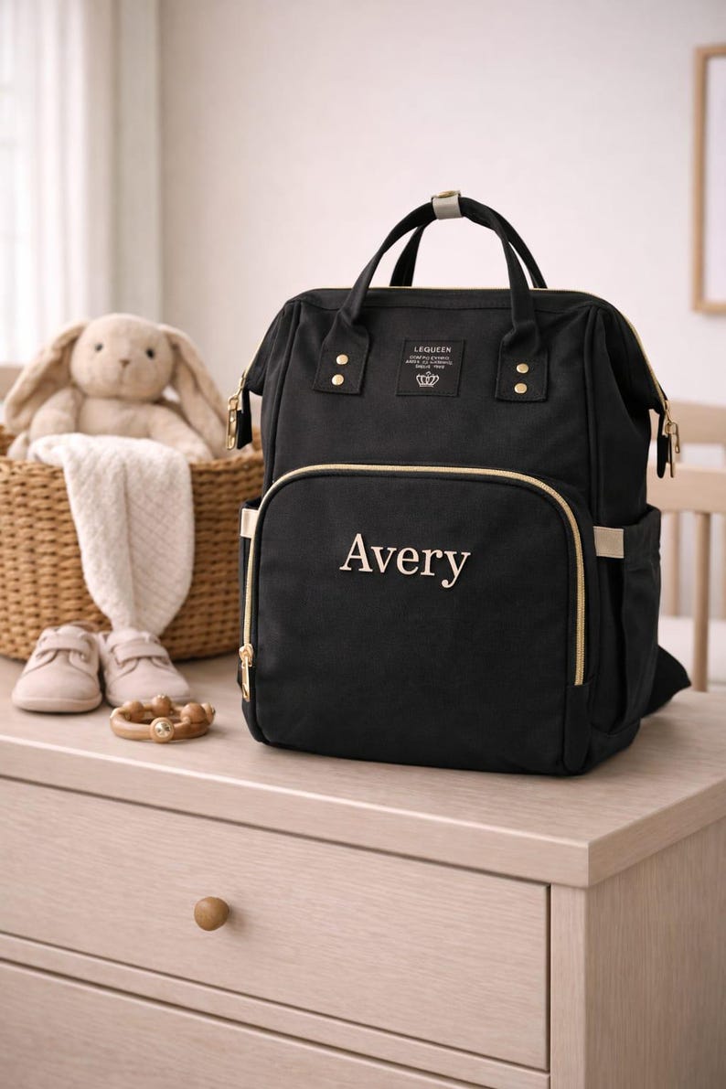 Black diaper bag with name Avery embroidered on front