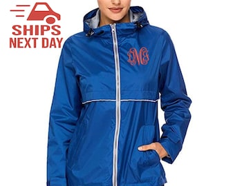 May include: A royal blue hooded jacket with a silver zipper and a white trim. The jacket has a monogrammed initial on the left chest.