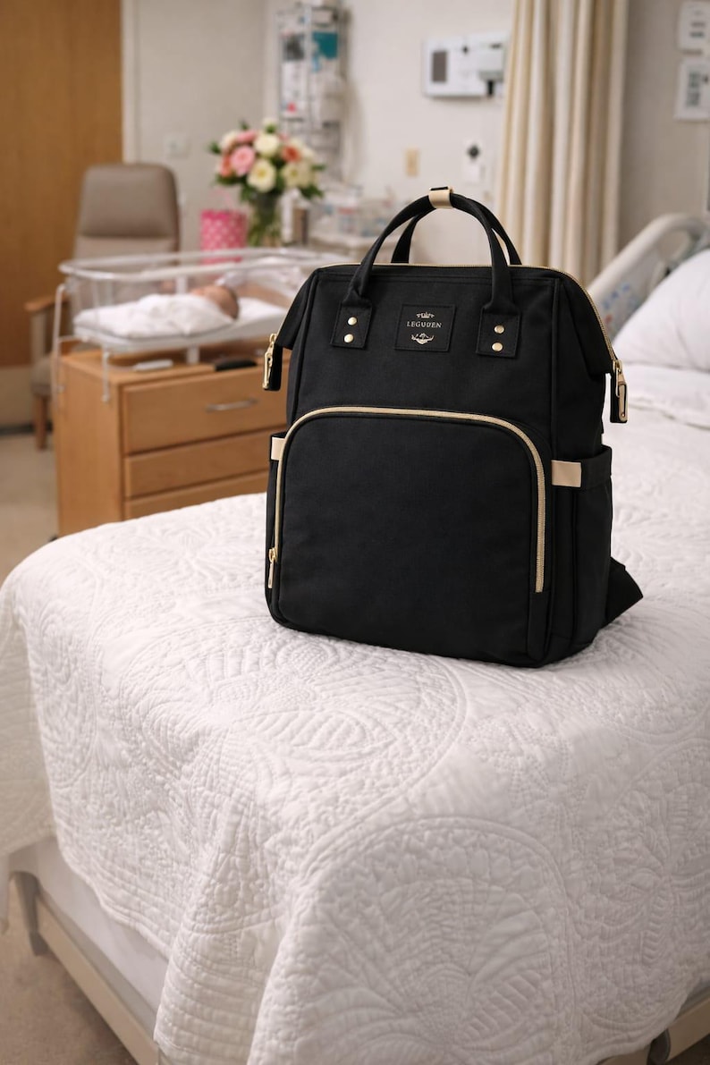 Black diaper bag on baby bed.