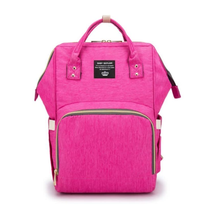 A pink diaper bag backpack with gold accents and a zippered pocket on the front.