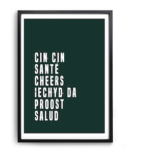 Könnte beinhalten: Ein gerahmter Druck mit dunkelgrünem Hintergrund und weißem Text, der "Cin Cin, Santé, Cheers, Iechyd Da, Proost, Salud" lautet.