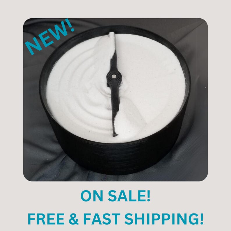 May include: A black sand timer with a white sand base and a black propeller. The sand timer is on a dark gray surface. The text "NEW!" is in the top left corner of the image. The text "ON SALE! FREE & FAST SHIPPING!" is in the bottom of the image.
