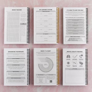 six spiral-bound notebooks with various prompts and exercises for self-reflection and personal growth.