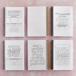 six spiral-bound notebooks with various designs and text on their covers.