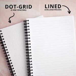 two notebooks, one with a dotted grid and the other with a lined page, both placed on a pink background.