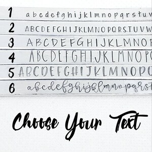 May include: A white wooden sign with six rows of letters, each row numbered 1 through 6. The letters are in different fonts and sizes. The letters are in black. The sign says "Choose Your Text".
