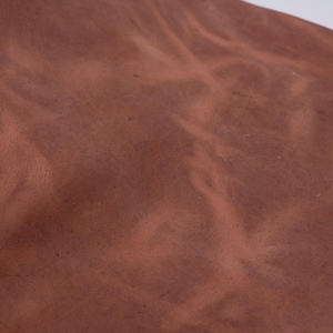 Fogli in pelle di cavallo pazzo color cognac rossastro. Pezzi in pelle pieno fiore anticata e pull up