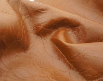 Brown cognac real leather sheet with wrinkles pattern. Creased effect genuine leather for diy crafts