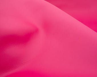 Może przedstawiać: Zbliżenie na żywy, błyszczący, intensywnie różowy materiał. Tkanina jest złożona, tworząc cienie i światła, które podkreślają jej fakturę i połysk. Kolor jest jednolity w całym obrazie.