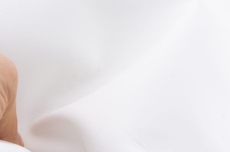 Pode incluir: Um close-up da pele contra um fundo branco. A pele &eacute; clara e lisa, com ligeiras varia&ccedil;&otilde;es de cor. O fundo branco cria uma est&eacute;tica limpa e minimalista.