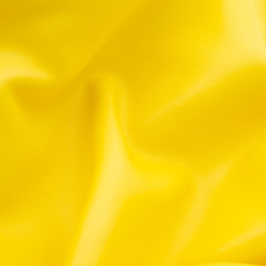Pode incluir: Um close-up de um tecido amarelo brilhante com uma superfície lisa e ligeiramente texturizada. O tecido está dobrado e drapeado, criando linhas suaves e fluidas.